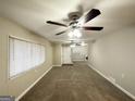 Open living room with neutral walls, carpet floors, ceiling fan, and ample natural light at 1761 Carter Cir, East Point, GA 30344
