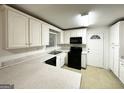 Well-lit kitchen with white cabinetry, black appliances, and ample countertop space at 2537 Bonnybrook Sw Dr, Atlanta, GA 30311
