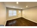 Bright living room featuring newly refinished hardwood floors, a front door, and fresh paint at 2819 Gresham Rd, Atlanta, GA 30316