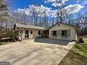 View of the house with a pergola and large concrete driveway surrounded by trees and landscaping at 1450 Victoria Ln, Oxford, GA 30054