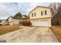 Two-story home with a front-facing two-car garage and covered front porch, providing curb appeal at 417 River Trace Dr, Villa Rica, GA 30180