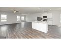 Open-concept living room with hardwood floors and abundant natural light, flowing into the kitchen at 1033 Claas Way, Locust Grove, GA 30248