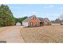 Spacious brick home featuring an attached two car garage and lush front yard at 234 Thorne Wood Ln, Hampton, GA 30228