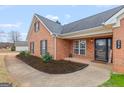 Charming brick home with a welcoming front porch, landscaped flower beds, and a stylish entrance at 234 Thorne Wood Lane, Hampton, GA 30228