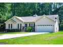 Inviting ranch-style home featuring a spacious driveway and an attached two-car garage at 3266 Greenhill Ct, Villa Rica, GA 30180