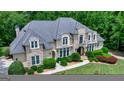High angle of a meticulously landscaped home with manicured lawn and surrounding mature hardwood trees at 709 Prestige Pt, Peachtree City, GA 30269