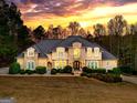 Beautiful two-story home with stone and stucco exterior against a colorful sunset backdrop at 709 Prestige Pt, Peachtree City, GA 30269