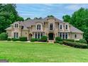Elegant home with manicured lawn and mature trees providing shade and privacy at 709 Prestige Pt, Peachtree City, GA 30269