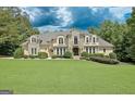 Beautiful stone and stucco home featuring a well-manicured lawn and lush landscaping at 709 Prestige Pt, Peachtree City, GA 30269