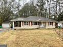 Inviting single-story home with red shutters, large trees, and detached garage at 733 Linda Way, Forest Park, GA 30297