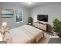 Comfortable staged bedroom with a large window, TV, dresser, and neutral decor at 61 Barrington Pl, Marietta, GA 30066
