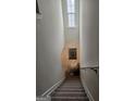Carpeted staircase features a charming window, handrail, and a decorative mirror, creating an inviting path to the next level at 2764 Keystone Ave, Lithonia, GA 30058