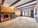 Spacious living room with a brick fireplace, large bay window, and neutral carpeting, offering cozy ambiance at 3140 Jodeco Dr, Jonesboro, GA 30236