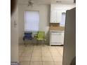 Bright kitchen area with white cabinets, tile floors and natural light from the window at 2400 Reynolds Sw Rd, South Fulton, GA 30331