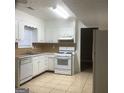 Functional kitchen featuring white cabinets, a gas range, and tile flooring for easy maintenance at 2400 Reynolds Sw Rd, South Fulton, GA 30331