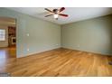 Spacious living room boasts natural light and hardwood floors leading to the brick fireplace in the next room at 155 Carole Dr, Oxford, GA 30054