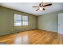 Inviting living room with hardwood floors, a ceiling fan, and natural light streaming through the window at 155 Carole Dr, Oxford, GA 30054