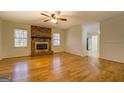 Open living area featuring a brick fireplace, hardwood floors, and large windows for ample natural light at 155 Carole Dr, Oxford, GA 30054