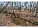 Beautiful two-story home nestled among trees, complemented by a private stream and natural landscape at 613 Rock Springs Pass, Dallas, GA 30157