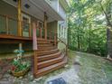 Inviting porch featuring wooden stairs, decorative railings, and lush greenery, creating a tranquil entry at 613 Rock Springs Pass, Dallas, GA 30157