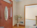 Home's entryway with a decorative flower tree, wood flooring, and a red door at 13789 Woolsey Rd, Hampton, GA 30228