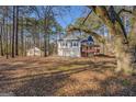 Exterior view of house with two-car garage and storage building on large wooded lot at 787 N Ola Rd, Mcdonough, GA 30252