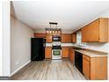 Well-lit kitchen with stainless steel appliances, wooden cabinets, and modern lighting fixtures at 530 Dillon Dr, Douglasville, GA 30134