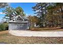 Detached two-car garage with a wide driveway surrounded by mature trees and landscaping at 1954 Saybrook Ct, Jonesboro, GA 30236