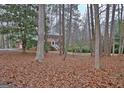 View of the brick home from a distance through a wooded lot at 200 Deer Forest Trl, Fayetteville, GA 30214