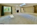 Bright living room with large windows, fireplace, skylight and neutral carpet, creating a comfortable atmosphere at 1327 Highway 54 E, Fayetteville, GA 30214