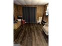 Bedroom featuring vinyl flooring and wood paneling with a rocking chair at 9055 Kelly Ct, Jonesboro, GA 30236