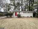 Single story home with a red front door, front bushes and a front lawn at 3696 Aldea Dr, Decatur, GA 30032