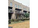 Brick townhome featuring a metal balcony with wrought iron railings, offering a stylish, modern exterior at 1028 Robert Smalls Way, Atlanta, GA 30318