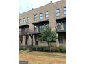 Exterior view of brick townhomes featuring small balconies and manicured landscaping at 1028 Robert Smalls Way, Atlanta, GA 30318