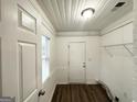 White mud room with white walls, beadboard, and vinyl flooring at 1158 Edgefield Sw Dr, Atlanta, GA 30310