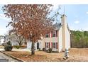 Two-story home with beige siding, red shutters, and a well-maintained lawn at 2916 Ward Lake Way, Ellenwood, GA 30294
