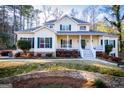 Charming two-story home boasts a welcoming front porch and beautifully landscaped front yard at 7364 N Mitchell Ct, Villa Rica, GA 30180