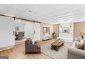 Spacious living room with brick accent wall, modern furniture, and sliding barn door to dining room at 6973 Stephens Dr, Rex, GA 30273