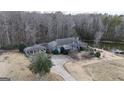 Home surrounded by a wooded area with a circular driveway and pond at 1187 Attaway Road, Roopville, GA 30170