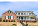 Charming two-story brick home with green shutters and a welcoming front porch at 135 Oakpark Ter, Mcdonough, GA 30253