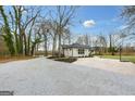 Exterior angle of a home showcasing a circular driveway and verdant yard at 757 Fischer Rd, Sharpsburg, GA 30277