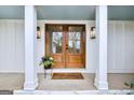 Inviting front entrance with double doors, potted plants, and a welcome mat at 757 Fischer Rd, Sharpsburg, GA 30277