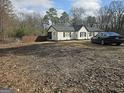 Exterior view of a home with a car parked nearby and a fenced yard at 3930 W Side Pl, Ellenwood, GA 30294