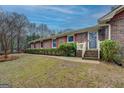 Inviting brick home with red shutters, featuring a well-kept lawn and a welcoming front porch at 308 Tulipwood Sw Cir, Conyers, GA 30094