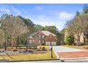 Beautiful home with brick accents, three car garage and a manicured lawn at 100 Windmeadow Way, Fayetteville, GA 30214