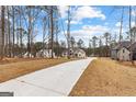 Scenic view of a long driveway leading to a beautiful home nestled among tall trees at 130 Windchime Way # 9, Tyrone, GA 30290