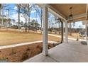 Inviting porch area with detailed columns and a tranquil view of the surrounding landscape at 130 Windchime Way # 9, Tyrone, GA 30290