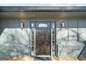 Stylish front door with sidelights and decorative glass, flanked by modern sconces at 2692 Fairview Rd, Covington, GA 30016