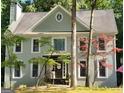 Charming two-story home with gray siding, black front door, and mature trees at 230 Wyngate Cir, Fayetteville, GA 30215