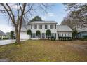 Traditional two-story home with manicured landscaping, a gray roof, and dark shutters at 3973 Laurel Bend Dr, Snellville, GA 30039